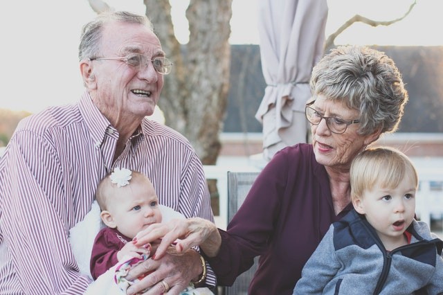 Grandparents enjoying time with their grandchildren outside their rent to own home while their children are at work